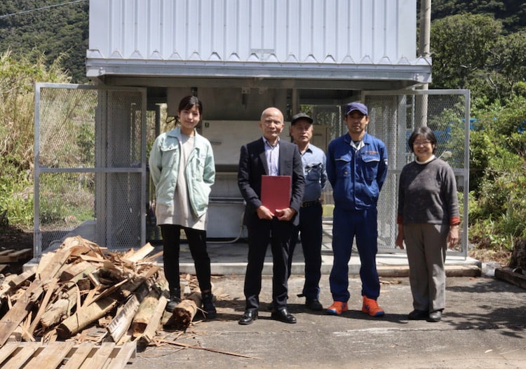 引き渡しの様子。立川住夫村長（左から2番目）は今年の念頭あいさつで「小型焼却炉を導入し、脱炭素へ向けて小規模ながらその一端を担いたい」と意欲を話した。
